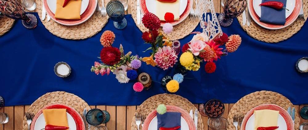 A vibrant royal blue table runner on an outdoor event table.