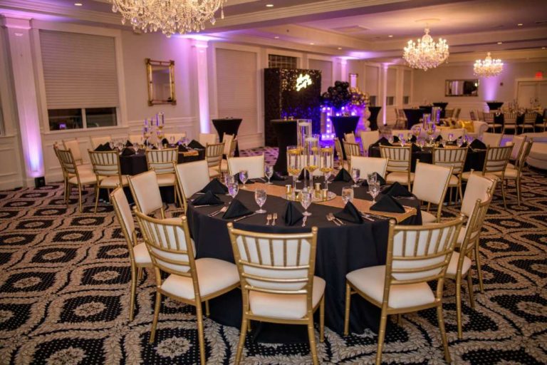 A black and gold tablescape with black linens and black napkins